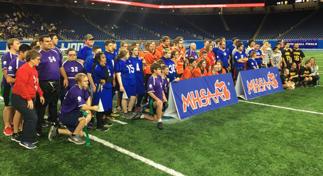 Six Unified high school flag football teams pose for a photo at Ford Field