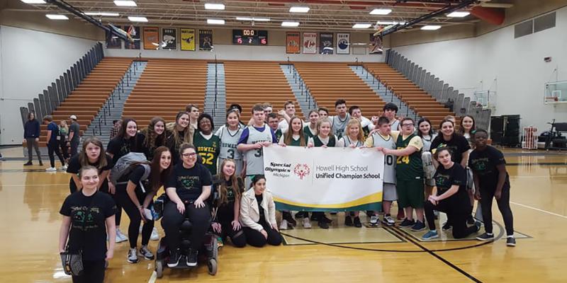 Students at Howell High School pose with a Unified Champion Schools banner.