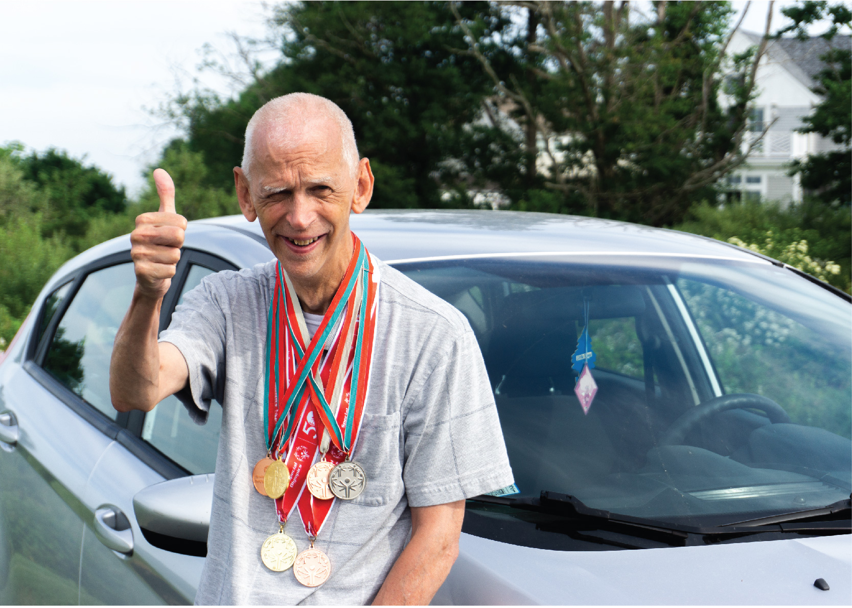 special olympics athlete infront of car